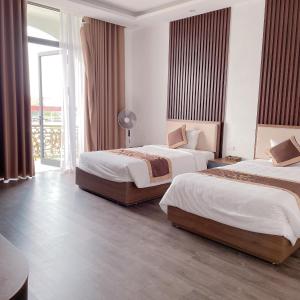 ein Hotelzimmer mit 2 Betten und einem Fenster in der Unterkunft Hoàng Liên Plaza in Na Cốc