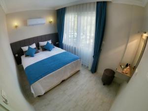 a bedroom with a large bed with blue pillows at MirAlya Homes in Fethiye