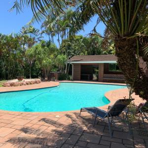 a swimming pool with two chairs and a house at Villa Incognito in Clansthal