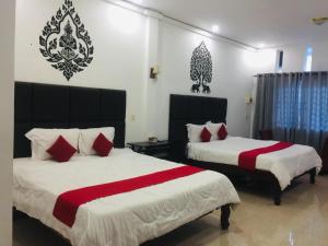 una camera con due letti con lenzuola rosse e bianche di EZ Guesthouse a Phnom Penh