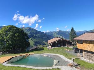 a small pool of water in front of a house at Sinnlehen Alm in Saalbach-Hinterglemm