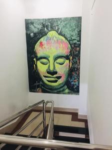 een schilderij van een groen gezicht op een muur bij EZ Guesthouse in Phnom Penh