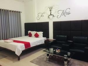 um quarto com uma cama e um sofá em EZ Guesthouse em Phnom Penh