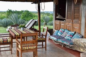 a patio with a table and chairs and a couch at Villa Moringa Lodge 