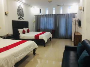 una camera d'albergo con due letti e un divano di EZ Guesthouse a Phnom Penh