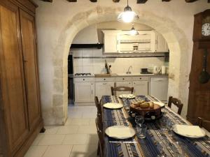 a kitchen with a table with a bowl of fruit on it at La maison forte in Mirebeau