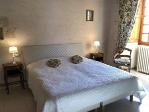 a bedroom with a bed with two pillows on it at La maison forte in Mirebeau