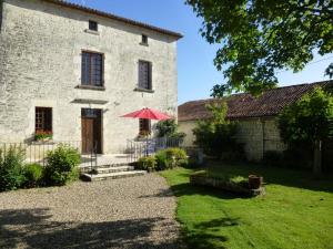 a building with a red umbrella in front of it at La maison forte in Mirebeau