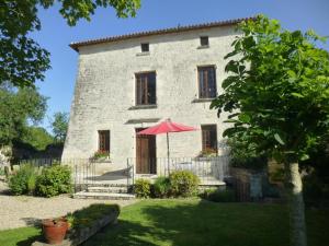a large stone building with a red umbrella in front of it at La maison forte in Mirebeau
