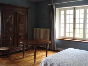 - une chambre avec une table, un lit et une fenêtre dans l'établissement La maison du regisseur, à Chauvigny