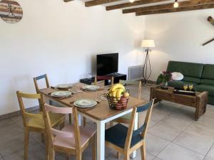 a dining room with a table and a green couch at La maison poitevine in Chauvigny