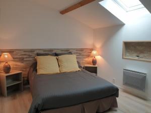 a bedroom with a bed with two lamps and a skylight at La maison poitevine in Chauvigny