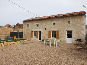 a stone house with a table and chairs in front of it at La maison poitevine in Chauvigny