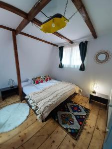 a bedroom with a bed in a room with wooden floors at Casa Ele in Frăsinet