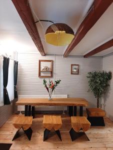 a dining room with a wooden table and benches at Casa Ele in Frăsinet