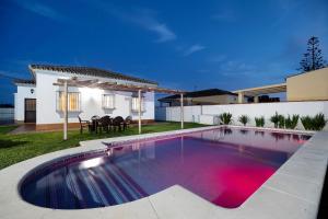 a swimming pool in the backyard of a house at Chalet Isla del Sotillo in Chiclana de la Frontera