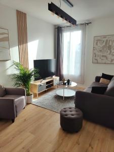 - un salon avec un canapé et une télévision dans l'établissement Superbe appartement proche la défense et Paris, à Bezons