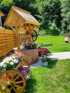 a garden with a wooden cart with flowers in the grass at Casa Ele in Frăsinet