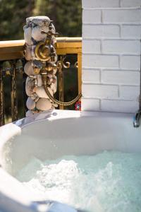 a bath tub filled with water next to asenalsenalsenalsenalsenalsenalsenal at Aloe Seaview Apartments with Private Spa Tub by Konnect in Dassia
