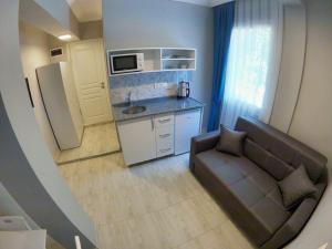 a small kitchen with a couch and a refrigerator at MirAlya Homes in Fethiye