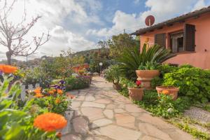 un giardino con fiori colorati e una casa di HelloElba Villetta Fiorita a Rio Marina