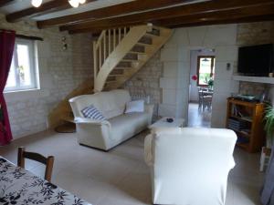 a living room with a white couch and stairs at Clé des champs in Antran