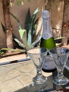 Una botella de champán y dos copas en una mesa. en Villa Casa Diego Ibiza en Santa Eulalia del Río