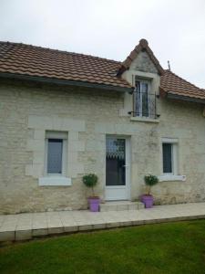 a house with two potted plants in front of it at Clé des champs in Antran