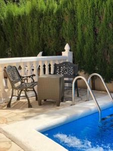 un patio con tavolo e sedie accanto alla piscina di Villa Casa Diego Ibiza a Santa Eularia des Riu