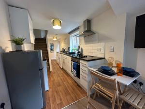 a kitchen with a refrigerator and a table with chairs at Number 3 Seafield - sleeps 4 - Grantham town in Lincolnshire