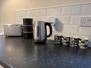 a coffeemaker sitting on a kitchen counter with coffee cups at Number 3 Seafield - sleeps 4 - Grantham town in Lincolnshire