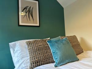 1 cama con 2 almohadas y una foto en la pared en Number 3 Seafield - sleeps 4 - Grantham town, en Lincolnshire