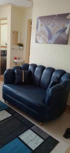 ein blaues Sofa im Wohnzimmer mit Küche in der Unterkunft SGH Furnished Studio Homes South B Nairobi in Nairobi