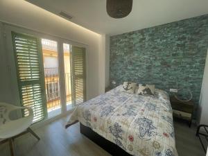 ein Schlafzimmer mit einem Bett und einer Ziegelwand in der Unterkunft ATICO - CANTOS DE SIRENA in Torremolinos