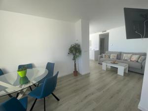 ein Wohnzimmer mit einem Tisch und blauen Stühlen in der Unterkunft ATICO - CANTOS DE SIRENA in Torremolinos