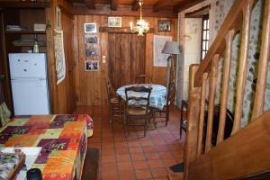 een kamer met een keuken met een tafel en een koelkast bij Le moulin de l'anglee in Sanxay