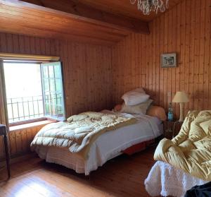 een slaapkamer met 2 bedden in een kamer met houten wanden bij Le moulin de l'anglee in Sanxay