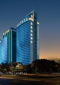 um edifício azul alto com luzes acesas em Shenzhenair International Hotel em Shenzhen