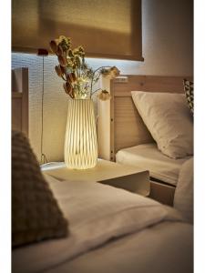 a vase with flowers sitting on a table next to two beds at Kyoto - Hotel - Vacation STAY 84499 in Kyoto