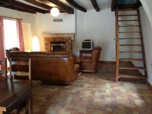 un soggiorno con divano e camino di La maison du fermier a Chauvigny