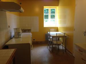 una piccola cucina con tavolo e sedie di La maison du fermier a Chauvigny
