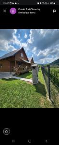 a picture of a house with a fence and a trash can at DOMKI POD CHMURKĄ in Solina