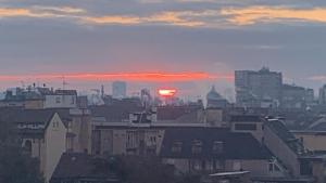 a city skyline with the sun setting in the distance at Mita Milano City Life Roof Garden in Milan