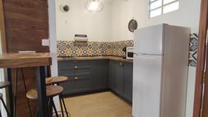 una cucina con armadi grigi e frigorifero bianco di Alameda Boho Chic a Siviglia