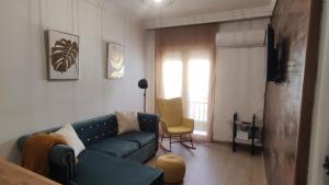 a living room with a blue couch and a yellow chair at Alameda Boho Chic in Seville