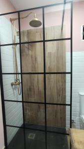 una doccia con porta in legno in bagno di Alameda Boho Chic a Siviglia