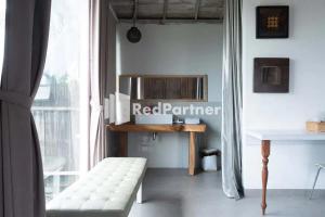 a room with a white bench in front of a window at Sawah Joglo Boutique Villa Mitra RedDoorz in Ngaglik
