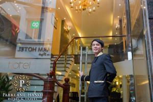 a man standing in front of a store window at Parklane Central Hanoi Hotel in Hanoi