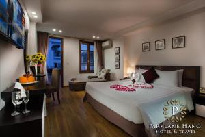 a bedroom with a large bed and a living room at Parklane Central Hanoi Hotel in Hanoi