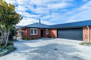 a red brick house with a garage at Contemporary Methven Abode in Methven